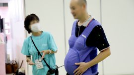 A visitor of Femtech Tokyo 2023 trying a pregnancy simulation